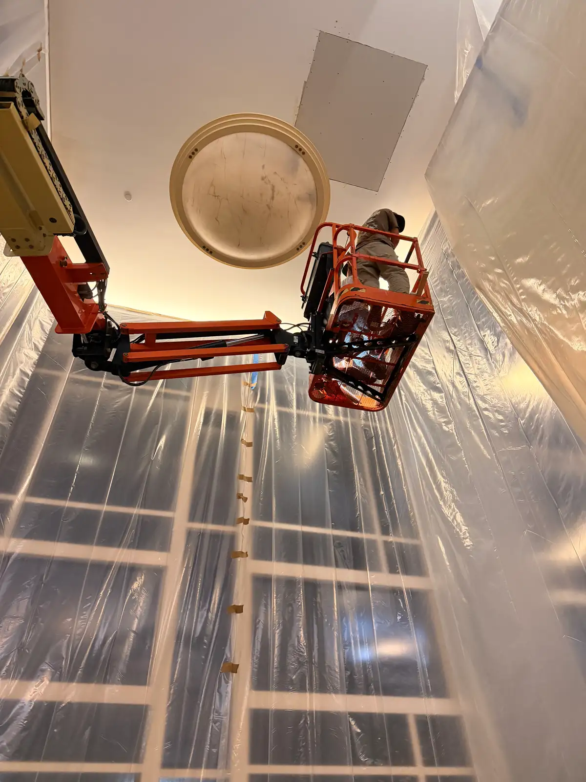 Fresh drywall ceiling patch and plastic containment after Mainline Plumbing completed an overnight commercial cast iron drain replacement at a hospital in Orange