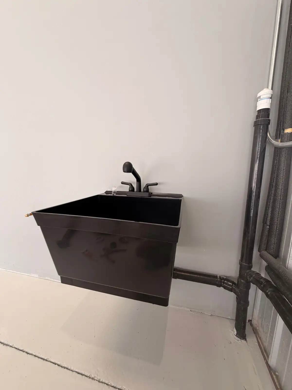 Newly installed commercial mop and utility sink with cast iron waste piping, plumbed and vented to code by Mainline Plumbing