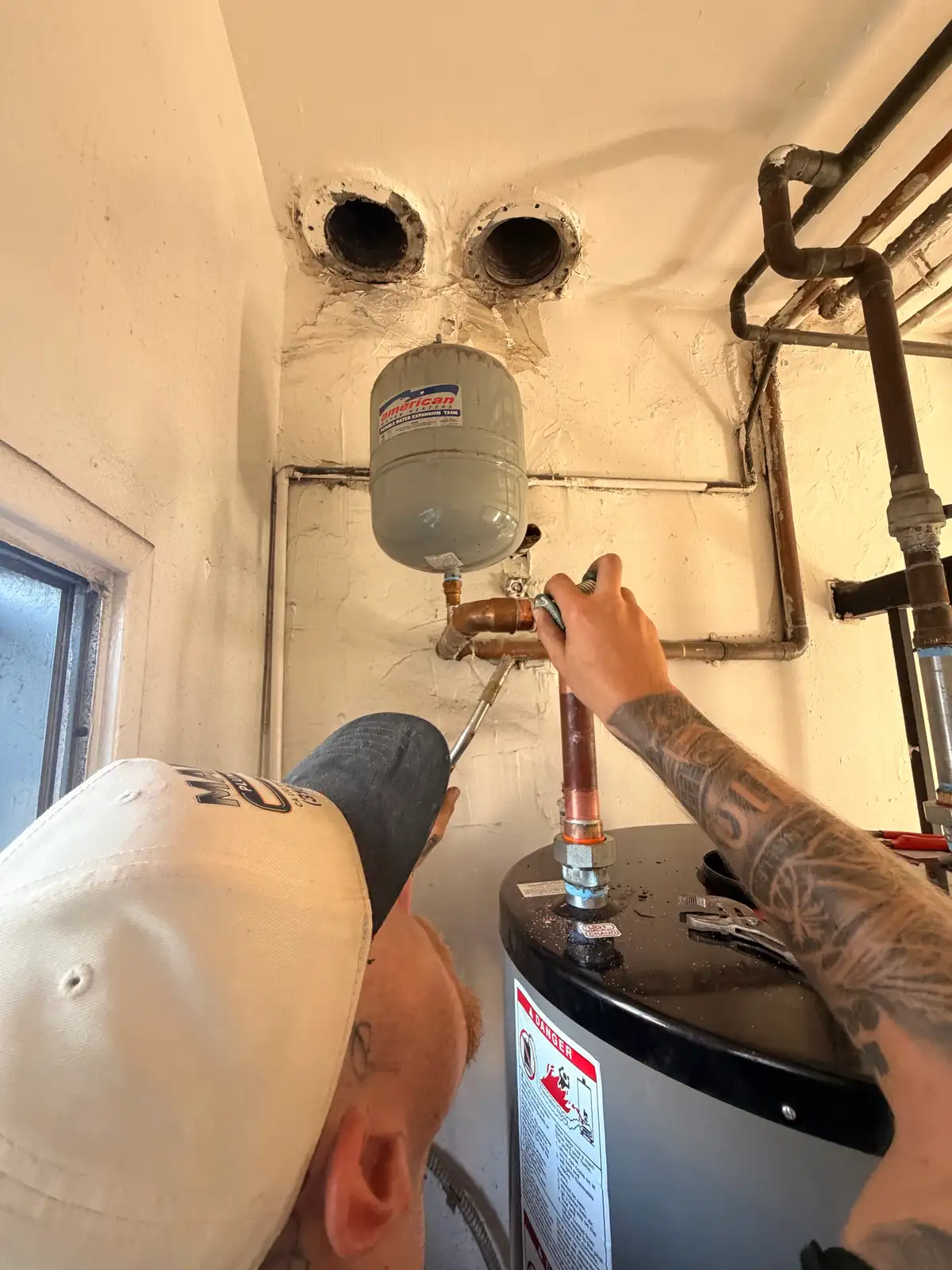 Final water and gas connections being made on a newly installed water heater