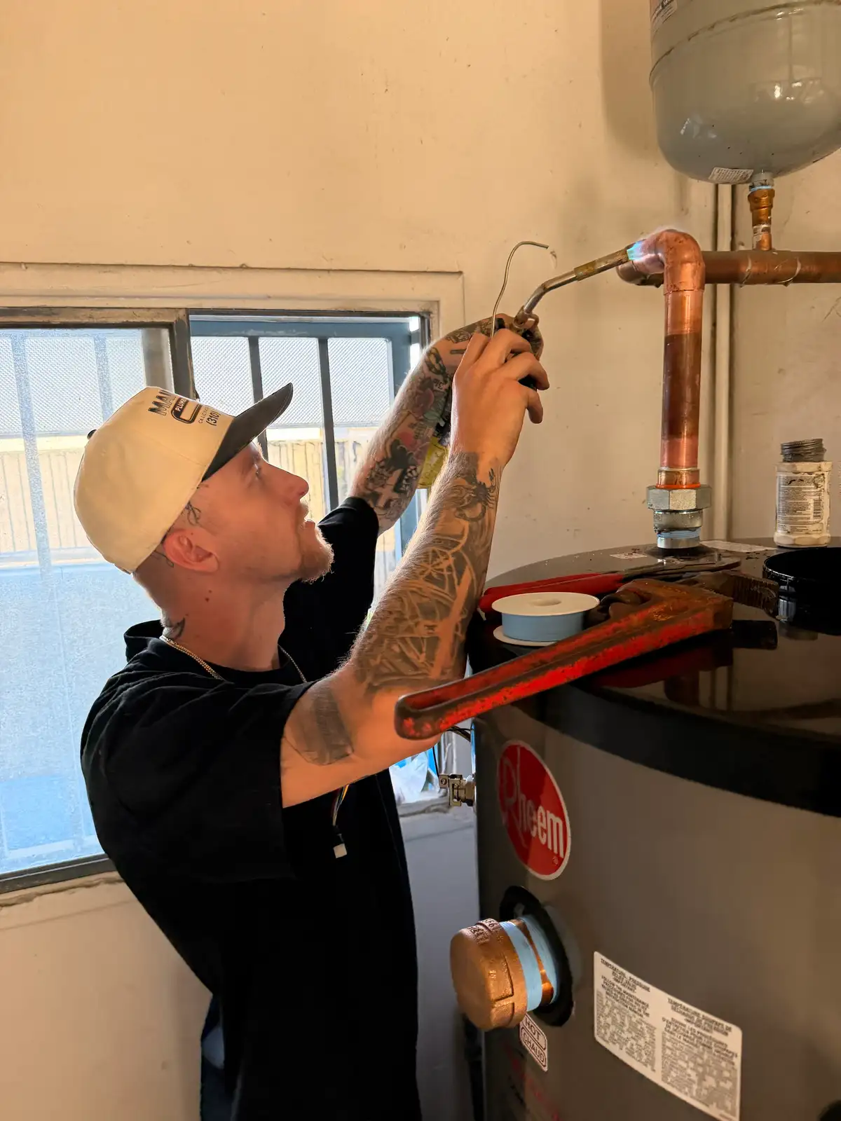 Close-up of a Mainline Plumbing technician using a torch to solder a lead-free copper joint during a copper pipe repair in the South Bay