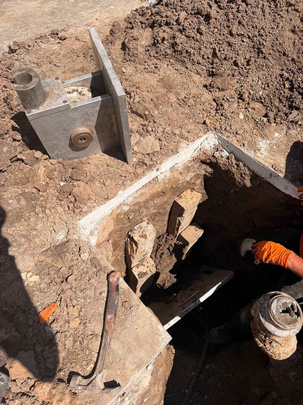 Pipe bursting rig mid-pull, fracturing the old host pipe outward as new HDPE follows behind