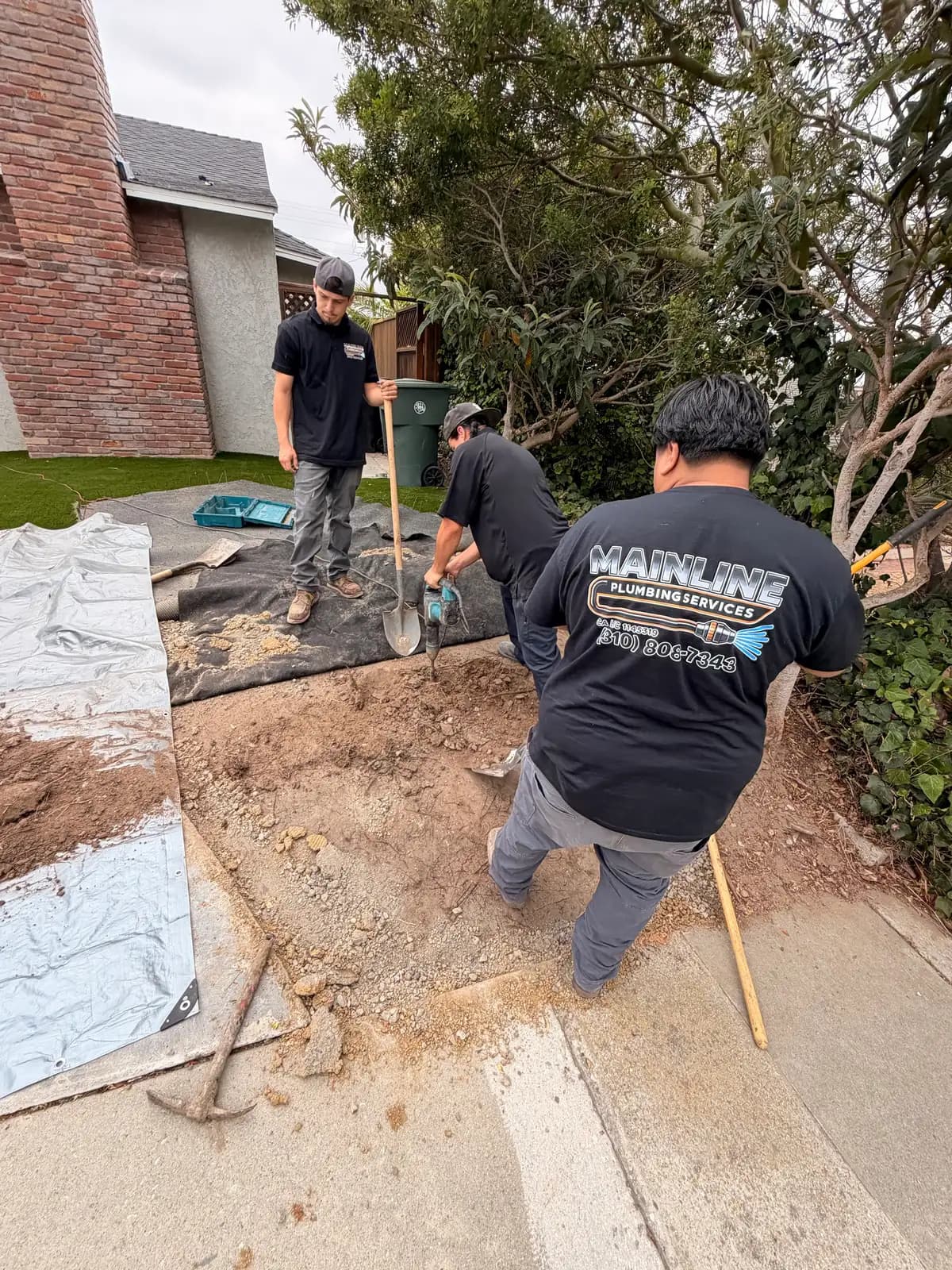 Mainline crew working a trenchless sewer replacement from a South Bay front yard